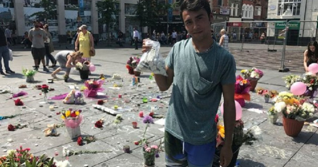 Un adolescent roman doarme in strada pentru a pazi lumanarile si florile depuse in memoria victimelor de la Manchester