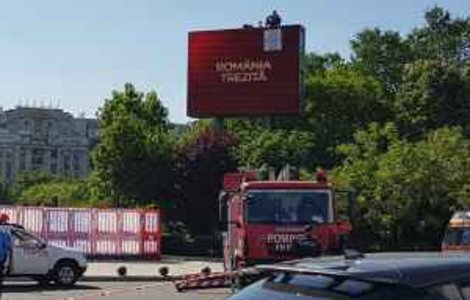 Un barbat protesteaza pe un panou publicitar in zona Piata Unirii din Bucuresti