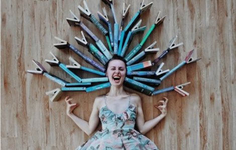 O tanara se foloseste de carti pentru a face creatii artistice