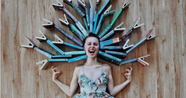 O tanara se foloseste de carti pentru a face creatii artistice