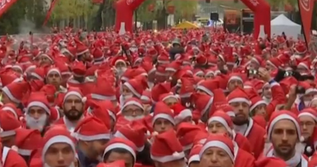 Mii de oameni imbracati in Mos Craciun au participat la o cursa de caritate in Madrid