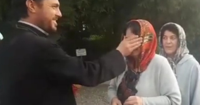 Un preot "plesneste" peste ochi credinciosii cu aghiasma, in curtea unei manastiri/ VIDEO