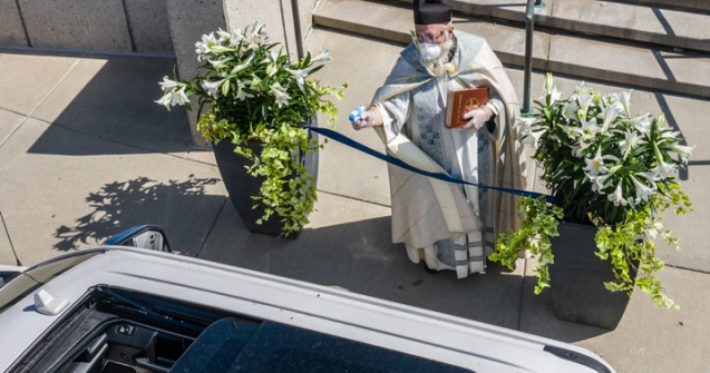 Preotul care respectă distanțarea socială: Binecuvântarea cu un pistol cu apă