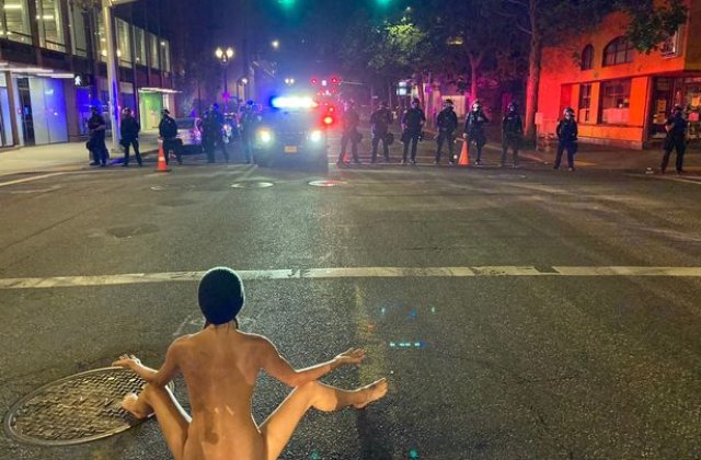 FOTO O t&acirc;nără s-a dezbrăcat complet și a făcut yoga la un protest, chiar &icirc;n fața polițiștilor