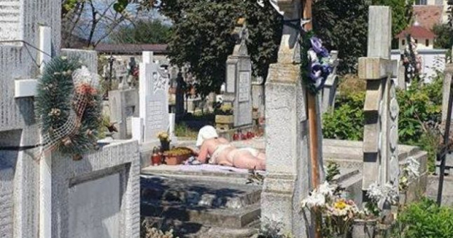 FOTO La plajă în cimitir. O femeie și-a întins pătura pe un mormânt