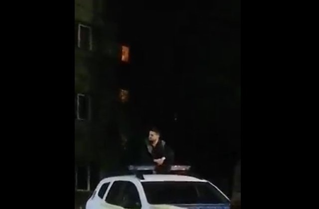 VIDEO Un bărbat a fost filmat pe tavanul unei mașini de poliție. Autoritățile au pornit o cercetare penală
