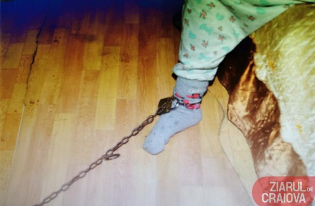 Bunică arestată la domiciliu, după ce și-a legat nepoata cu un lanț de piciorul patului