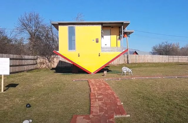 Casa răsturnată, unică din Rom&acirc;nia. Cum arată atracția cu acoperișul &icirc;nfipt &icirc;n păm&acirc;nt 