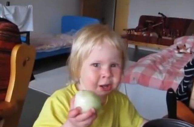 [VIDEO] AMUZANT! Un copil mananca o ceapa ca pe un mar