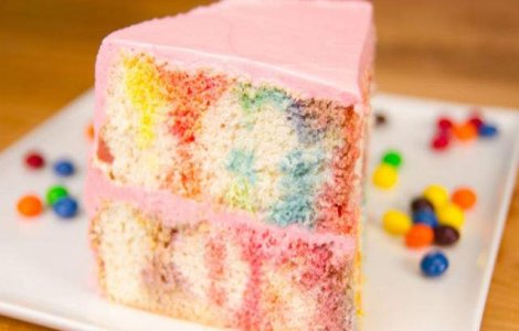 Adauga bomboane topite peste blatul de tort pentru un desert colorat