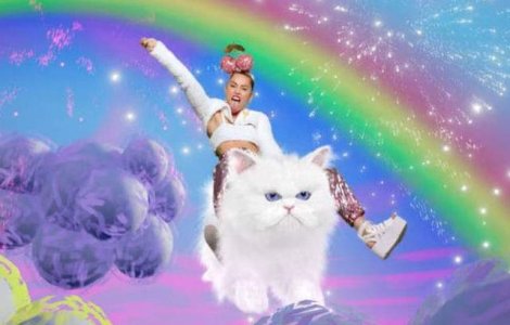 Miley Cyrus calareste o pisica uriasa pentru a promova MTV VMA