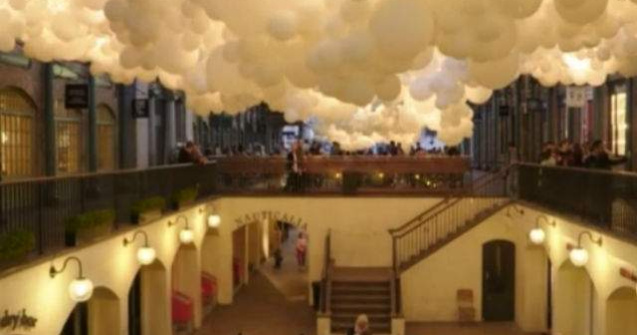 O suta de mii de baloane albe, suspendate in interiorul unei cladiri