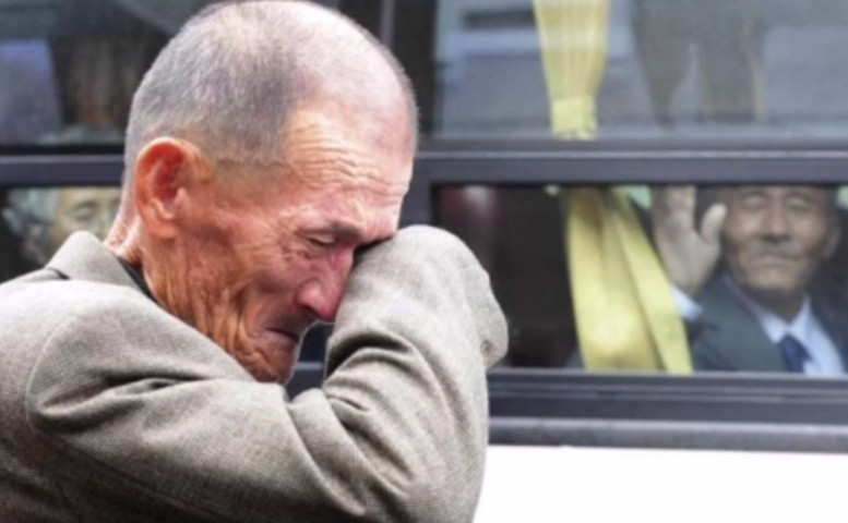 Un nord-coreean ii face cu mana unei rude care plange