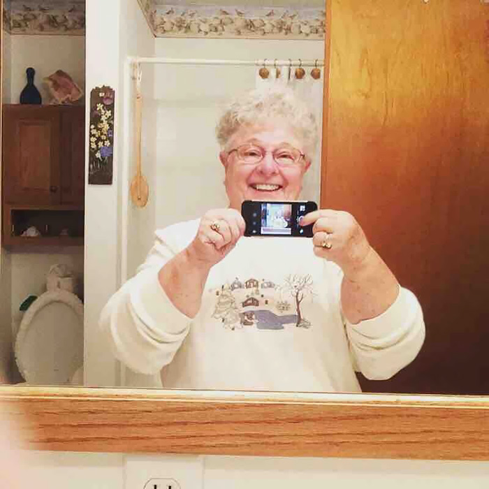 O bunica isi face pentru prima data un selfie. Foloseste camera frontala pentru a se fotografia in oglinda