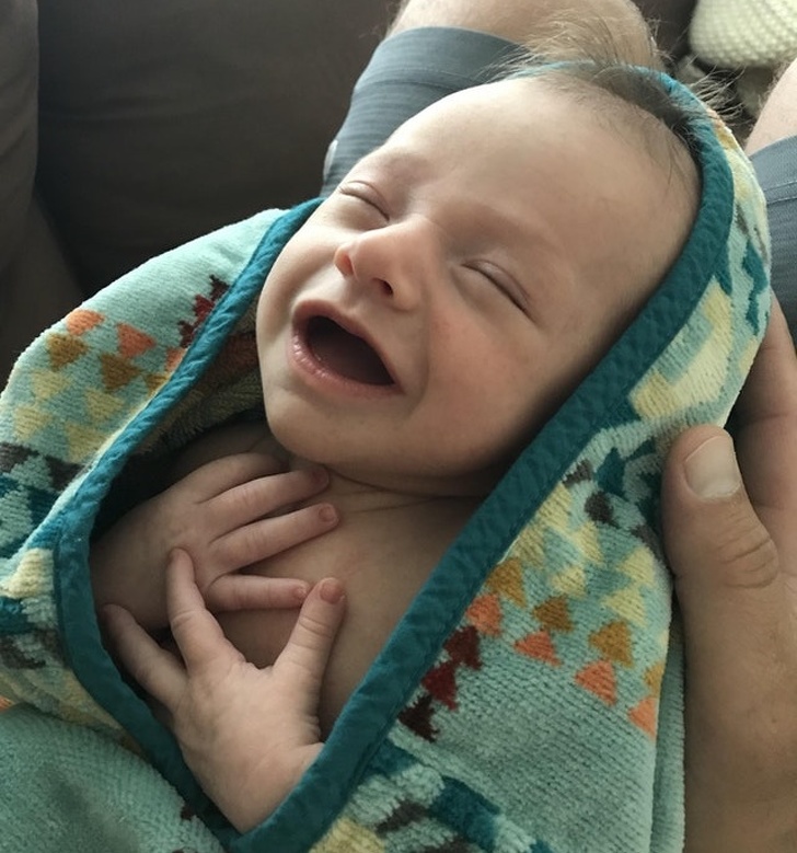 Chipul unui bebelus de doua saptamani, dupa ce a facut baie pentru prima data