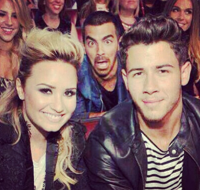 Fratele lui Demi Lovato, incercand sa-i strice poza vedetei. De fapt, a facut-o chiar mai amuzanta