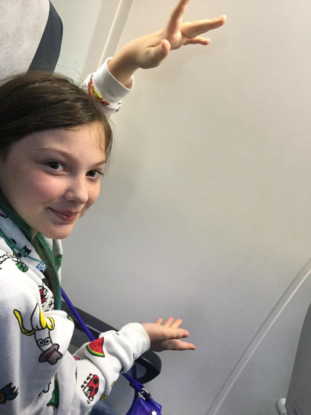O fetita foarte incantata ca, in sfarsit, avea loc la geam in avion. Din pacate, nu a fost ziua ei cea mai buna