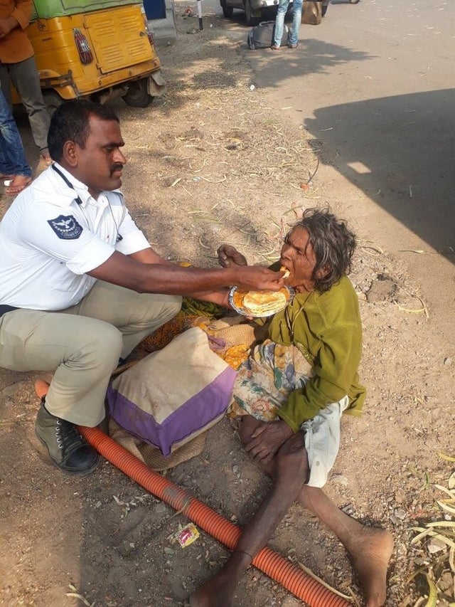Un politist de la rutiera din India hraneste o femeie, care era prea slabita pentru a putea manca singura