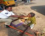 Un politist de la rutiera din India hraneste o femeie, care era prea slabita pentru a putea manca singura