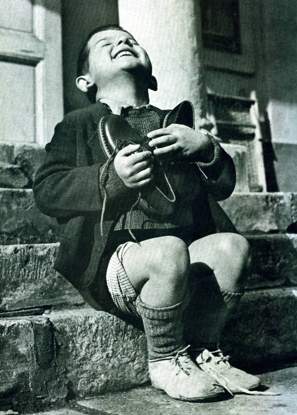 14. Reactia unui baietel care primea o pereche noua de pantofi, in timpul celui de-al Doilea Razboi Mondial