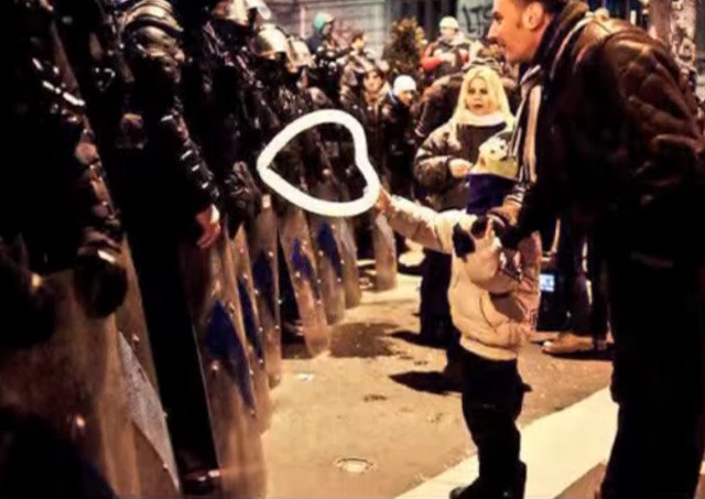 Un copil roman ofera un balon in forma de inima jandarmilor in timpul protestelor de la Bucuresti