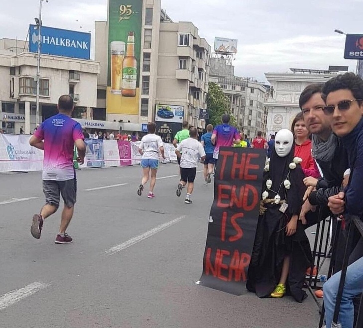 Sustinatori la maraton tinand o pancarta pe care scrie "Sfarsitul este aproape"