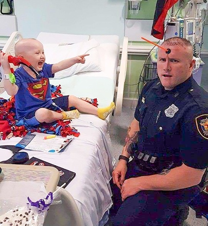 Un politist se joaca cu un copilas bolnav din spital